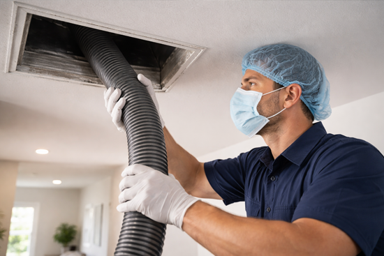 technician cleaning air ducts using vacuum hose